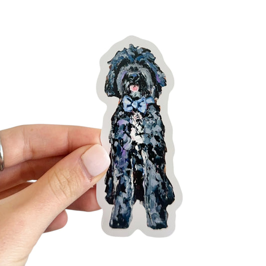 Black Goldendoodle with a blue bow dog vinyl removable sticker featuring artwork y Chelsea McShane. 